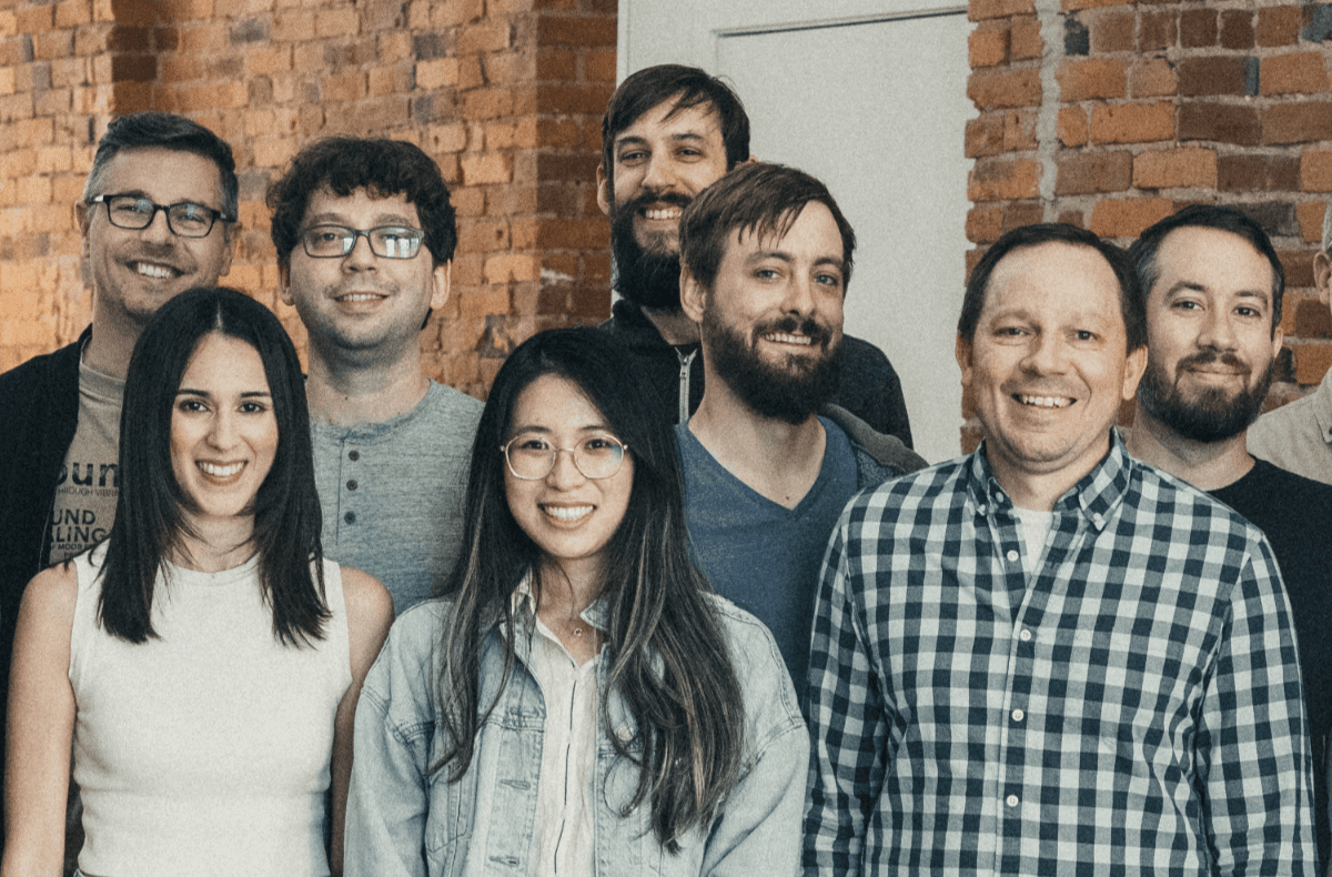 A group of developers standing together and smiling